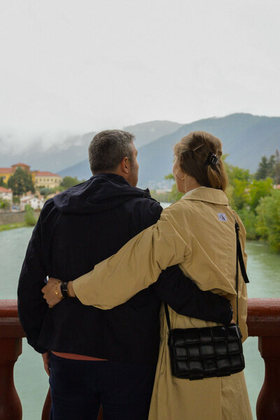 Chantelle and Giovanni, founders of The Italian on Tour, embrace while gazing at a stunning Italian landscape