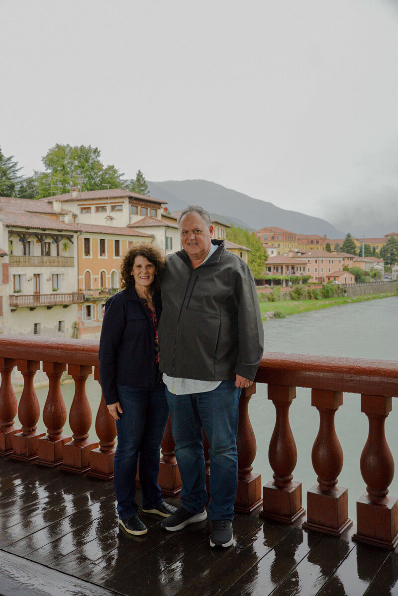 A happy couple posing on a bridge sharing their positive review of their small group trip with Italian on Tour