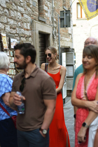A small group of travelers chats and explores a charming Italian village, capturing the connection and authenticity of a small group tour.