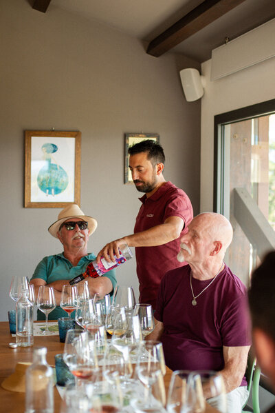 A waiter pouring wine into a customer's glass On the Italian on Tour’s Celiac-friendly Gluten Free Italy Tour