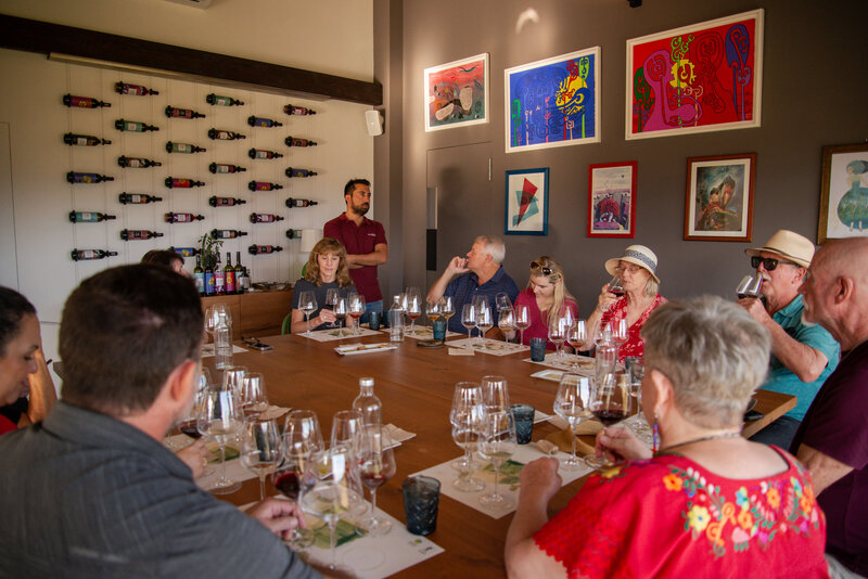 a small group of people sit around a dining table with wine glasses in front of them On the Italian on Tour’s 8 day Passport to Puglia Food & Wine Tour