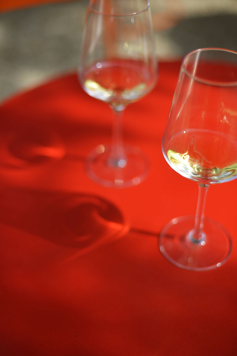 glasses of white wine on a red table