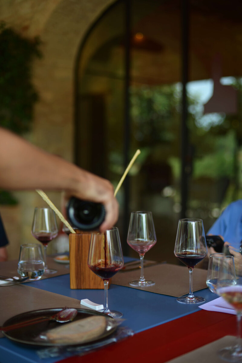 Wien being poured into a glass on a beautifully set table, highlighting an intimate wine tasting experience on a small group Italy tour