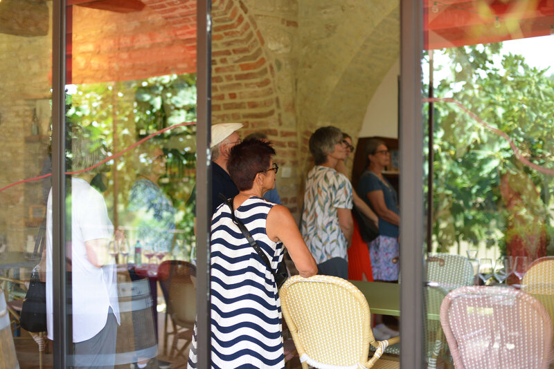 A small group of travelers attentively listens to a guide in a historic Italian setting, experiencing an intimate and immersive small group tour of Italy
