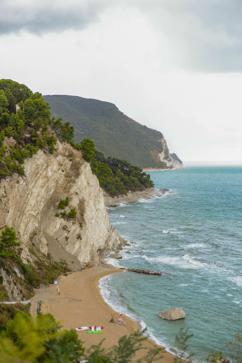 A breathtaking view of Italy’s rugged coastline, with cliffs meeting the turquoise sea, offering a serene escape on a small group tour.