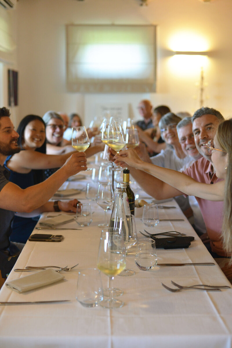 A group of people making a cheers during a meal On the Italian on Tour’s 8 day Passport to Puglia Food & Wine Tour