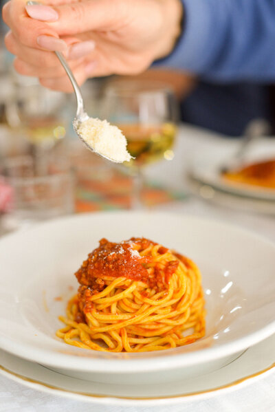 A plate of classic Italian spaghetti with rich tomato sauce, showcasing the delicious food experiences on an Italy small group tour.