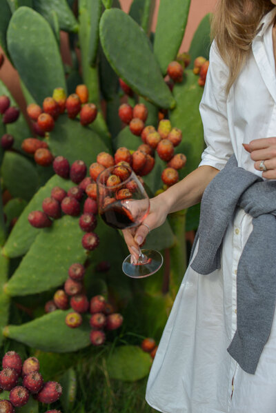 A woman holding a glass of red wine onOn the Italian on Tour’s Celiac-friendly Gluten Free Italy Tour