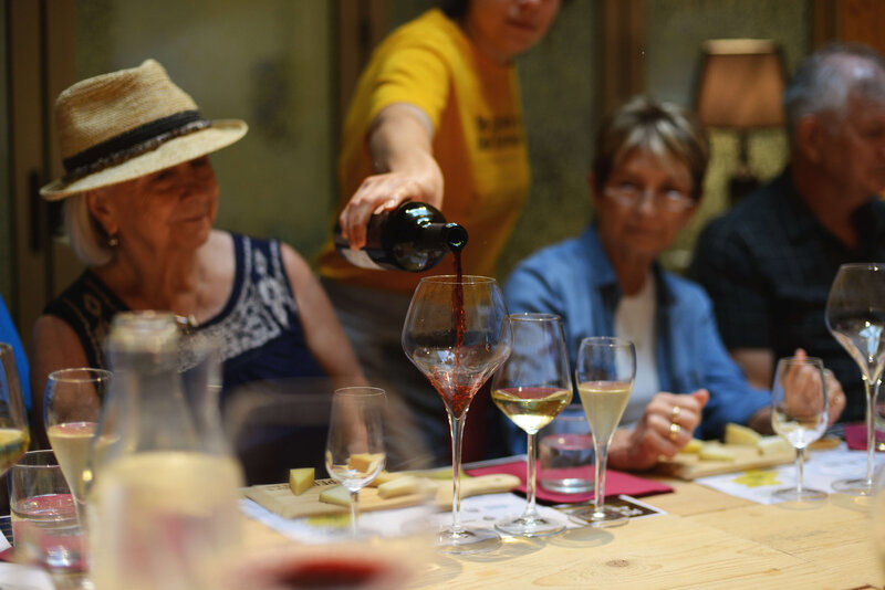 A person refilling a glass of wine for diners On the Italian on Tour’s 10 day Northern Italian Delights Food & Wine Tour