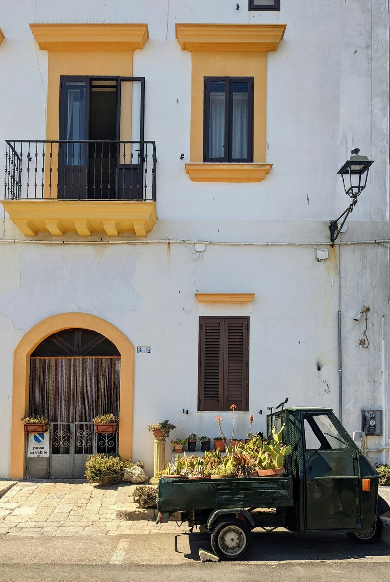 A classic White italian building with yellow windows On the Italian on Tour’s 8 day Passport to Puglia Food & Wine Tour