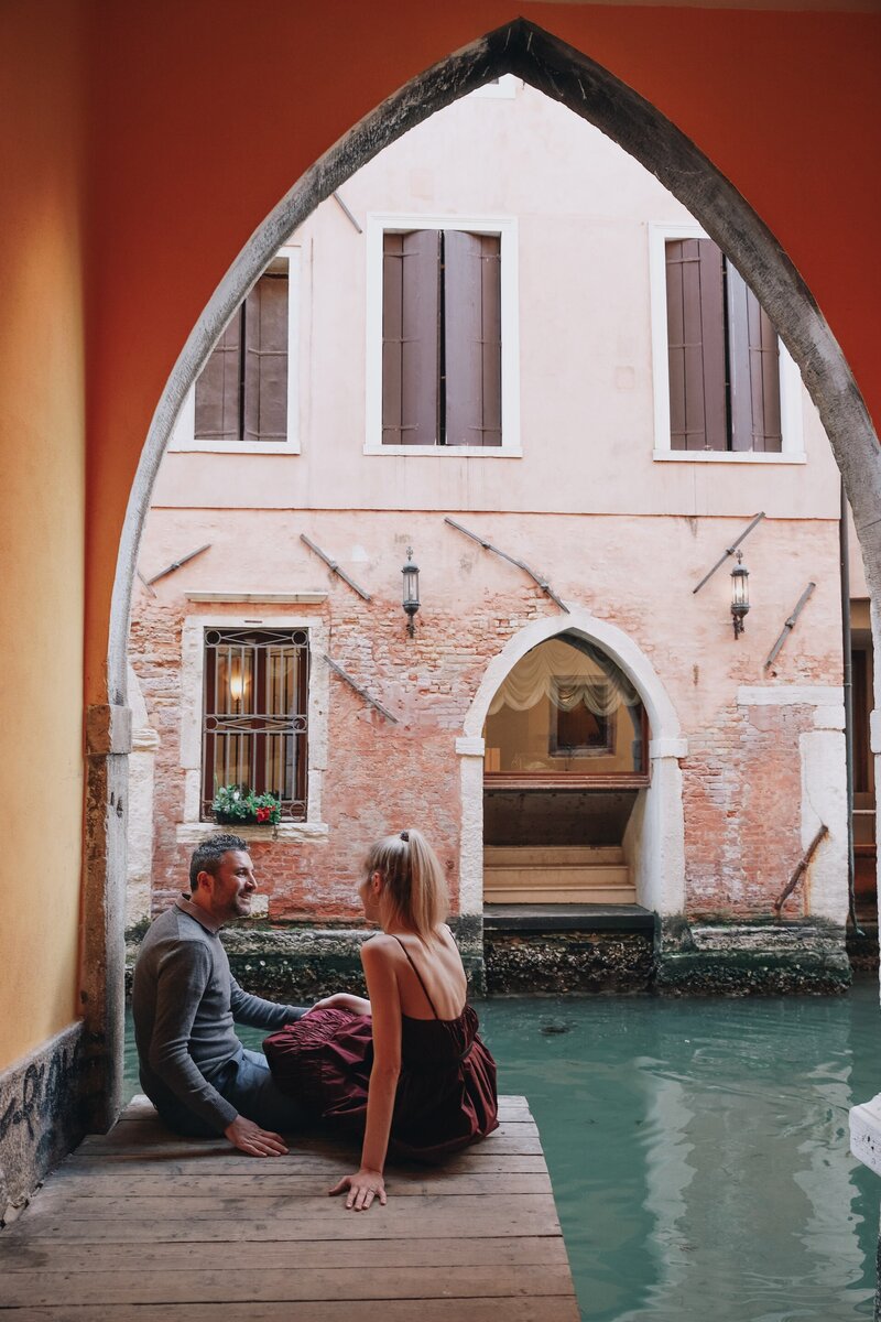 Chantelle & Giovanni sitting on an old waterway in Italy on the Northern Italy Delights Tour, a 10-day food and wine tour of Northern Italy from The Italian on Tour