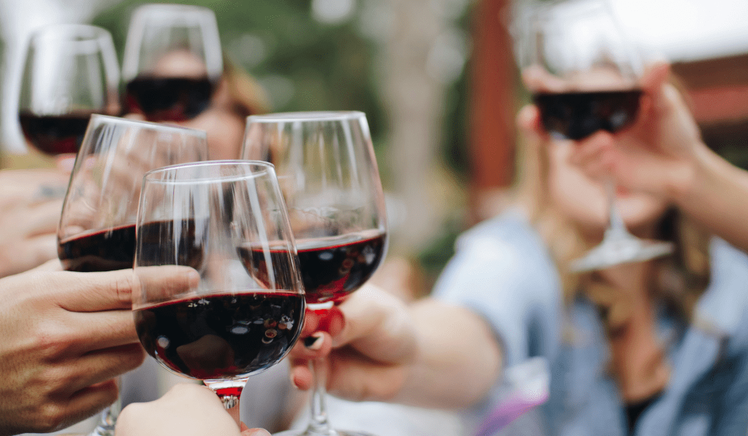 Hands holding wine glasses being clinked | The Italian On Tour