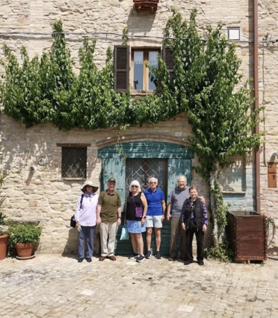 A small group of people pose for a photo outside On the Italian on Tour’s 10 day Northern Italian Delights Food & Wine Tour