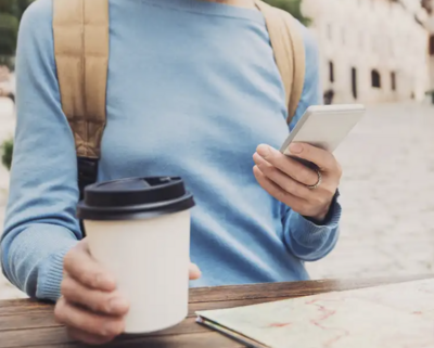 a person holding a coffee cup and texting